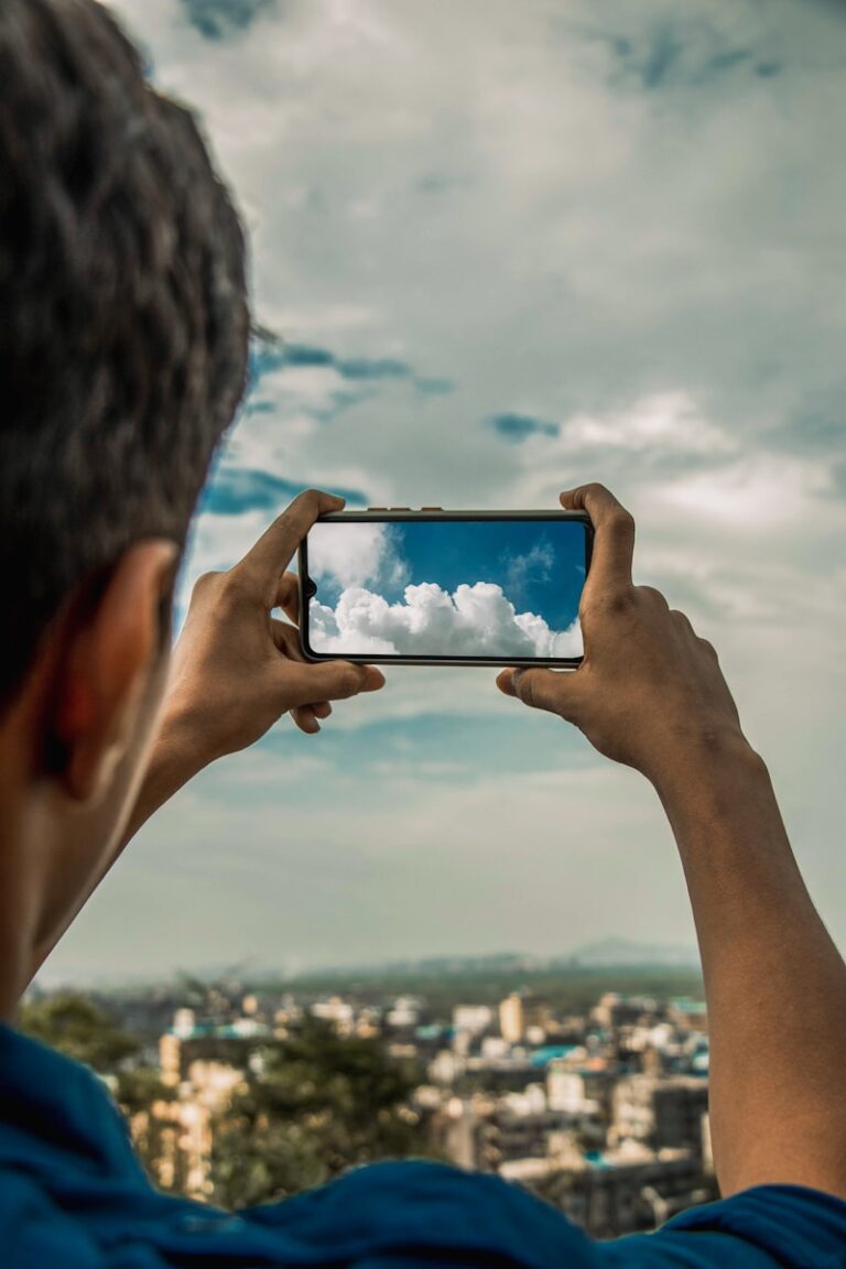a man taking a picture of the sky with his cell phone
