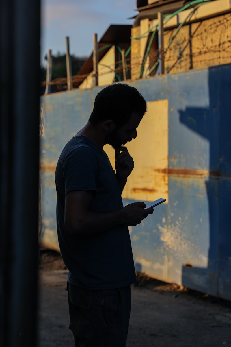 man in gray crew neck t-shirt holding smartphone