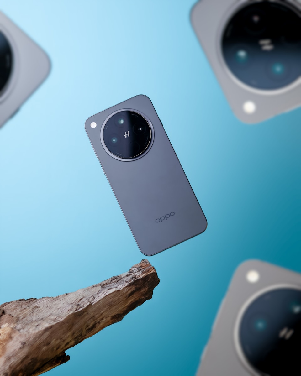 A close up of a cell phone near a tree branch